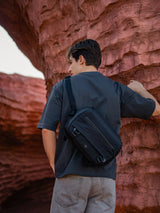 Black crossbody gear bag for creators and tech users. Compact everyday carry with strong zippers.