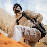 Built for movement—camera backpack worn during a climb, showing secure fit and all-day comfort in rugged terrain.