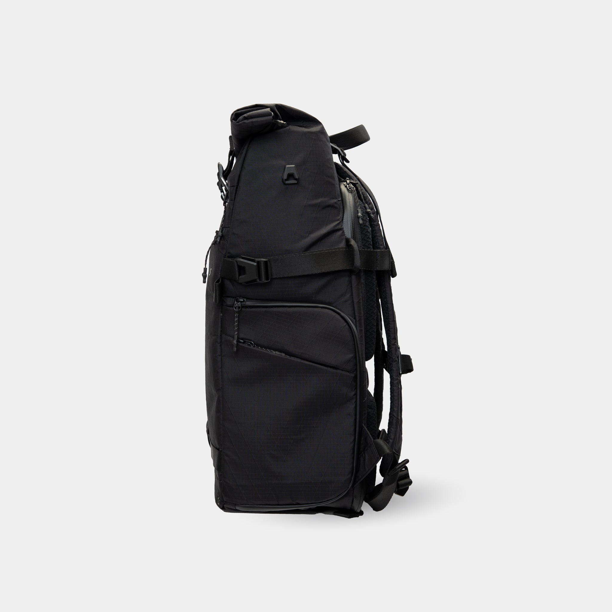 Slim side view showing compression strap, secure side pocket, and attachment point for modular gear add-ons.