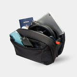 Slim sling bag holds travel tech accessories. Designed to fit inside any carry-on or tote.